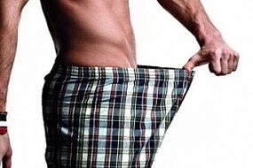 El hombre mira el pene y quiere aumentarlo